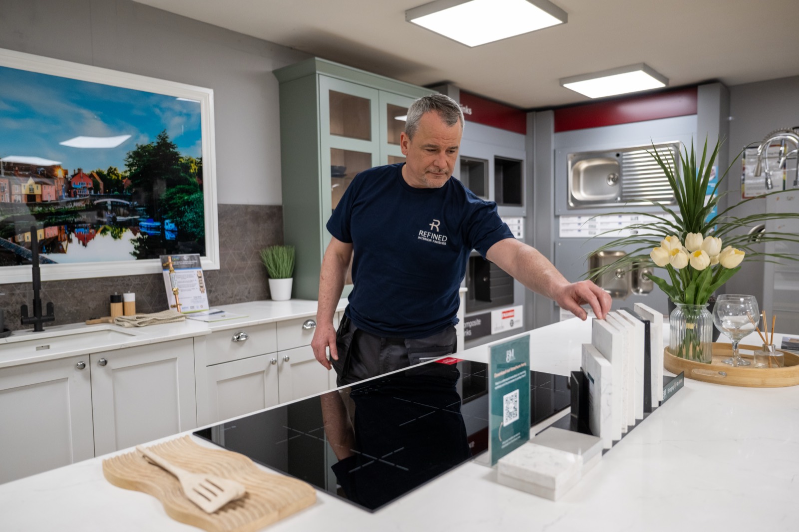 Refined Interior Finishes team member comparing worktop samples in the kitchen and bathroom showroom