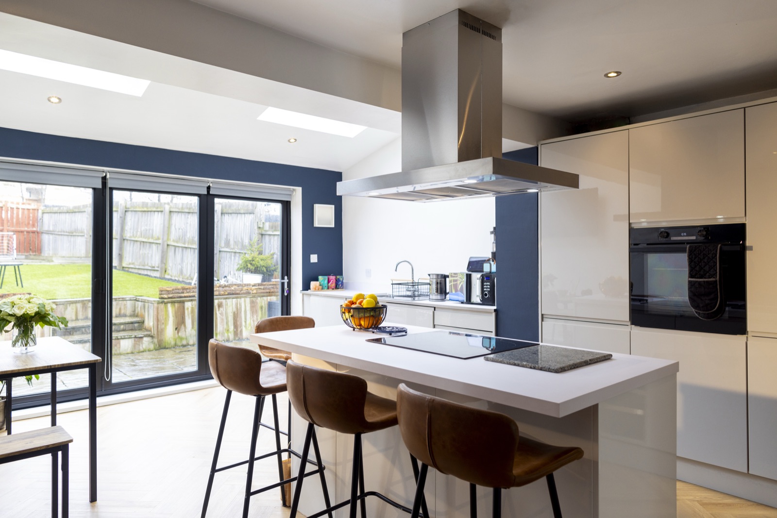Modern open-plan kitchen with a central island, induction hob and sliding doors to the garden