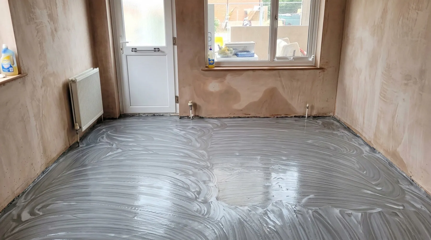 Adhesive applied to the prepared subfloor ready for LVT tile-effect flooring