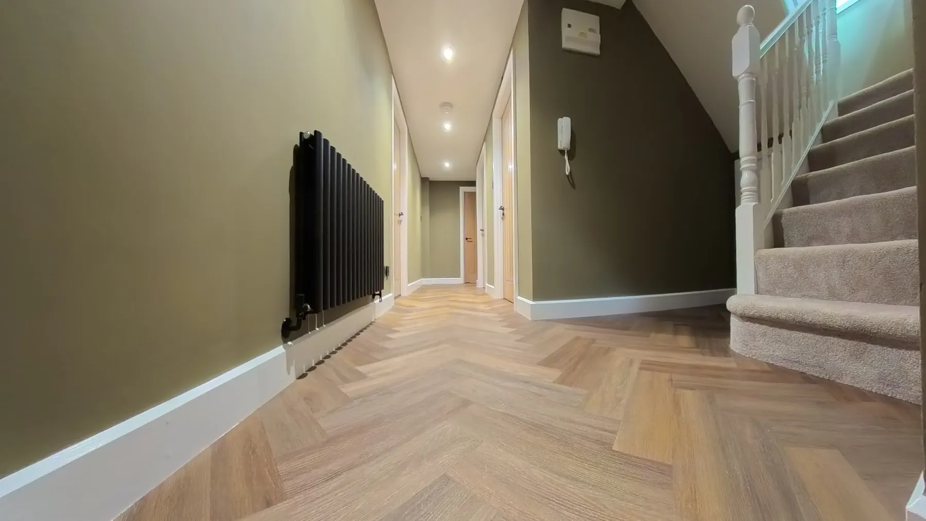 Herringbone LVT flooring running through the hallway towards the staircase