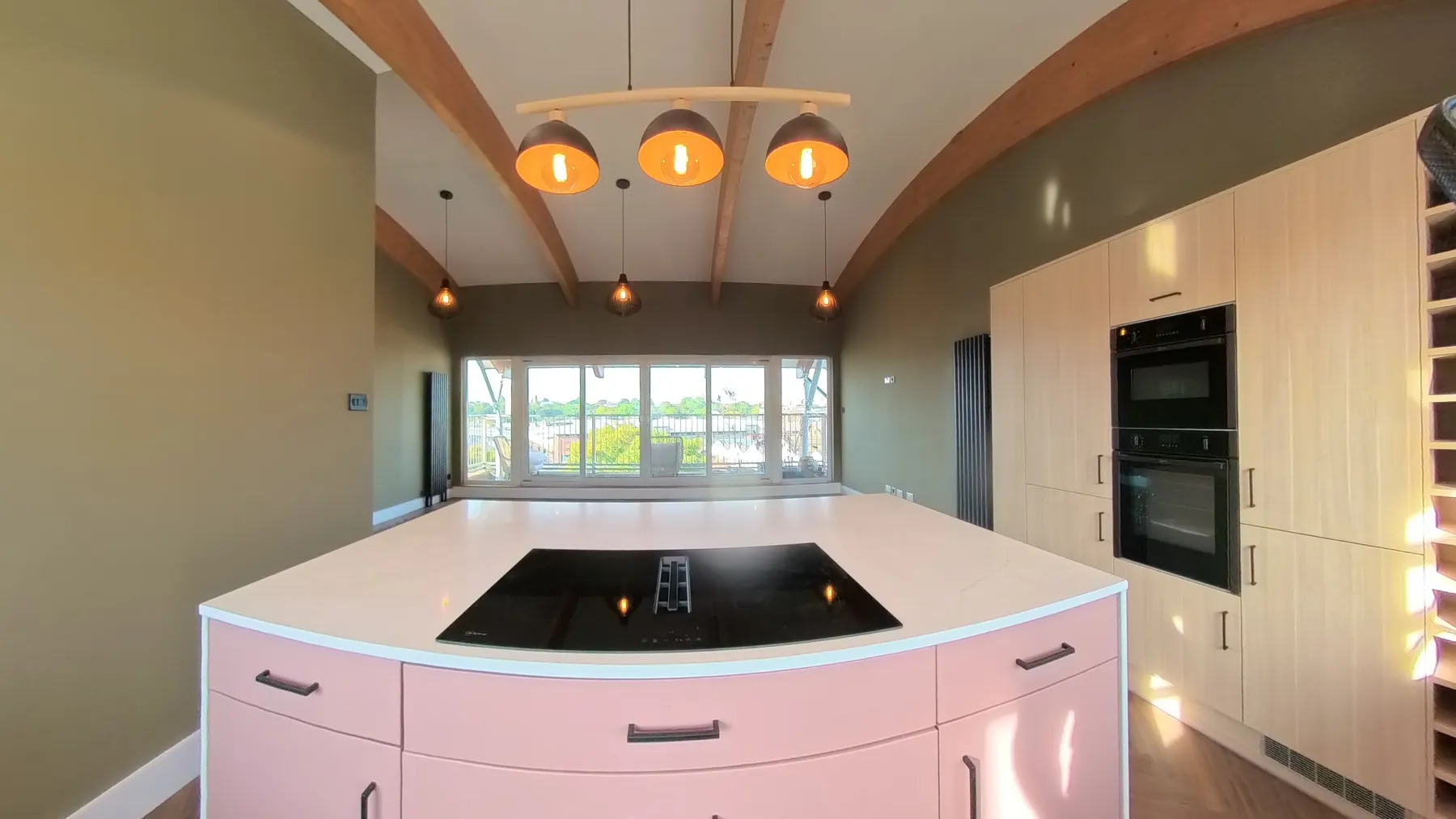 New kitchen island with an induction hob, seen across the herringbone LVT floor