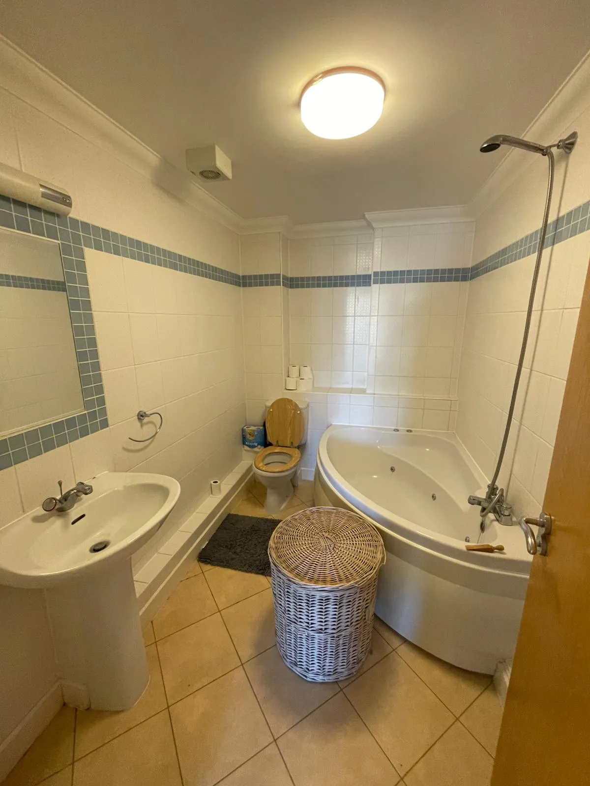 The dated main bathroom with a corner bath before renovation work began