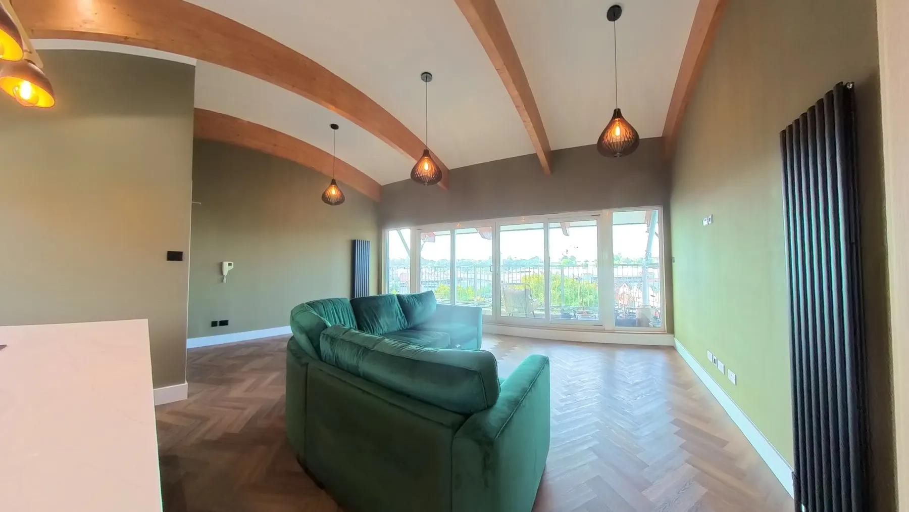 The same open-plan living space after renovation, with herringbone LVT flooring laid